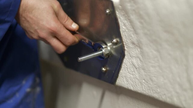 Tightening nyloc nut on bolt using spanner