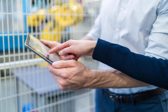 Close-up of businessman and businesswoman using tablet in modern factory