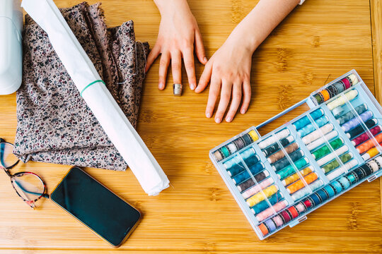 Close-up of girl with sewing items on table