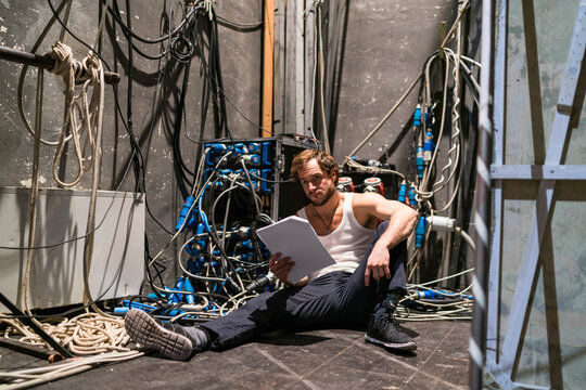 Actor with script rehearsing backstage