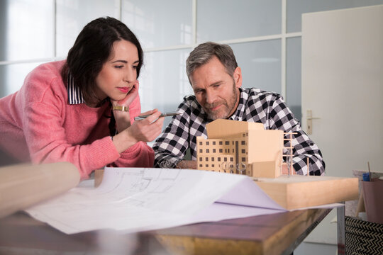 Colleagues examining architectural model in office