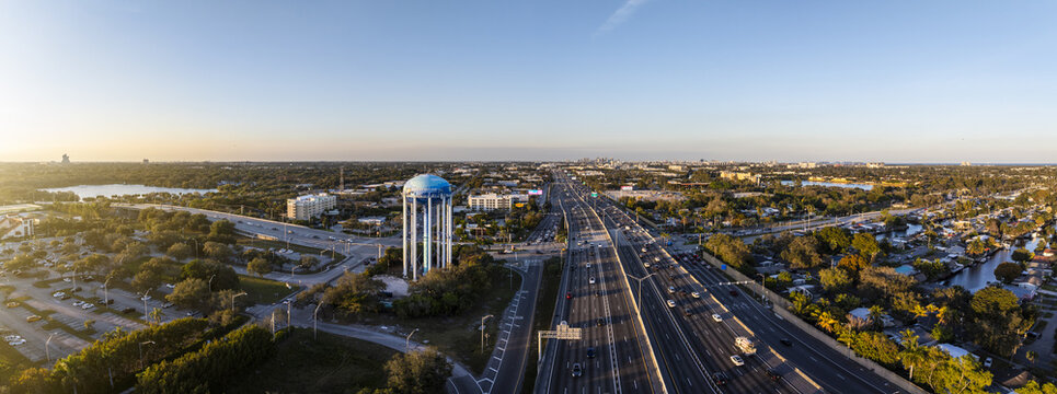 Aerial view of the water tower standing tall with its blue dome, overlooking the vast highway stretching into the horizon, Hollywood, Florida, United States.