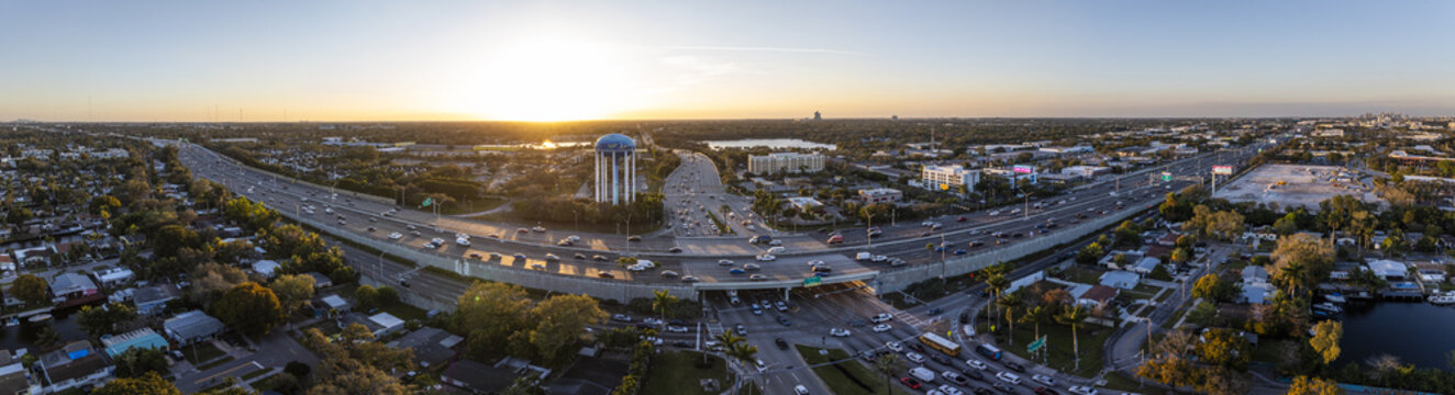Aerial view of the blue-domed water tower and busy highway cutting through residential neighborhoods under the golden light of the setting sun, Hollywood, Florida, United States.