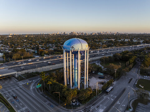 Aerial view of the Hollywood water tower rising majestically against the backdrop of the distant Miami skyline, bathed in the soft glow of the setting sun, Hollywood, Florida, United States.