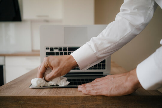 Businessman wiping the screen of his laptop