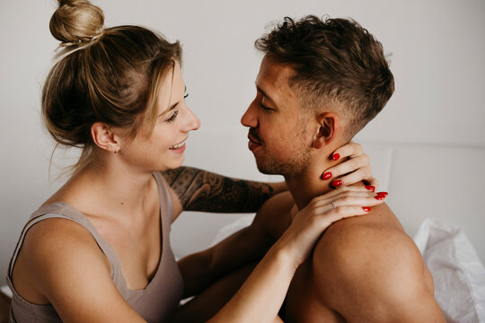 Happy young couple in bed smiling at each other