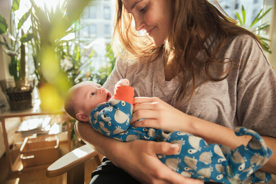 Mother caressing her newborn baby boy at home