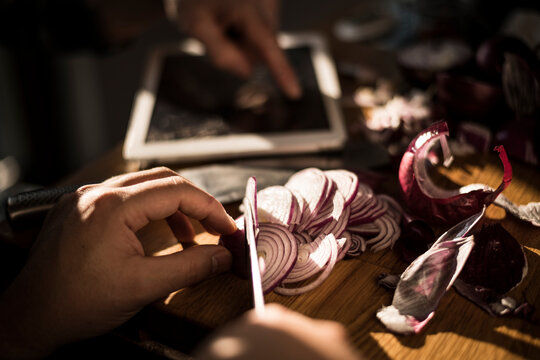 Hands chopping onions