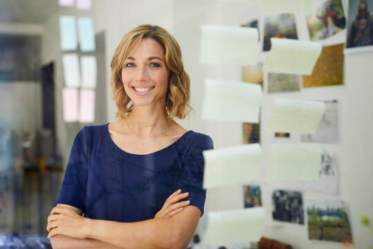 Portrait of smiling blond woman, pane with notepads