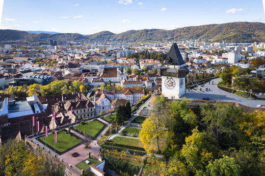 Aerial view of the iconic clock tower, the Grazer Uhrturm, stands proudly above the autumnal hues of the city, a testament to time and tradition, Graz, Styria, Austria.