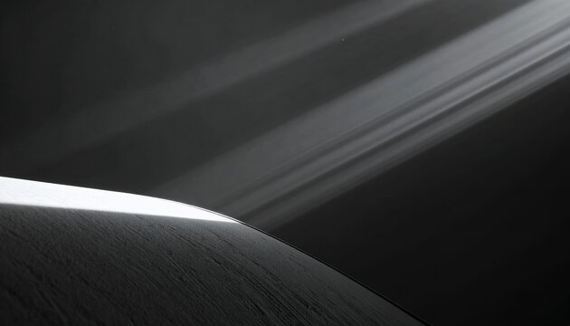 Czarno-białe ujęcie krawędzi planety z dramatycznymi promieniami światła i pierścieniami w tle, tworzące minimalistyczną kompozycję kosmiczną.