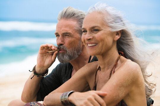 Senior hippie couple relaxing together on the beach
