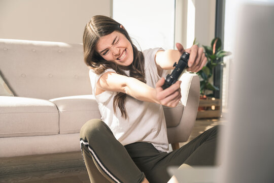 Happy young woman playing video game at home