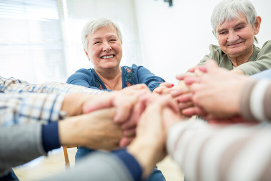 Group of active seniors stacking hands, symbolizing solidarity