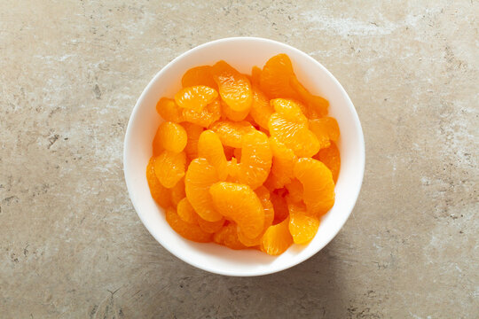 A top down view of a bowl of canned mandarin wedges.