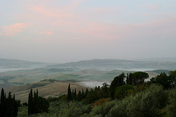 Obraz premium Soft autumn light illuminates the rolling hills of the Val d’Orcia near Pienza in the Province of Siena, Tuscany, Italy.
