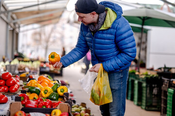 Man Choosing Peppers At The Vegetable Market