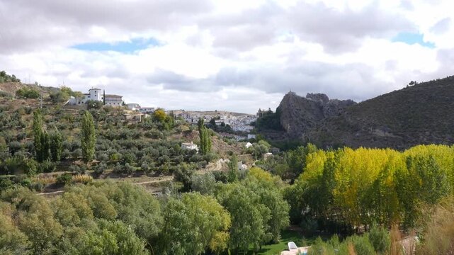 General view of the white village of Castril, nestled in the mountains. Autumnal colors in the valley, with poplars and olive trees.