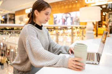 Young Woman Working Remotely On Laptop In Coworking Space In Mall