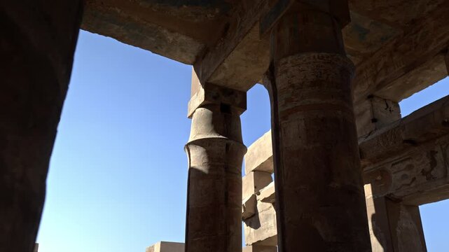 This low-angle shot captures the massive stone architraves resting atop the columns of the Great Hypostyle Hall at Karnak.