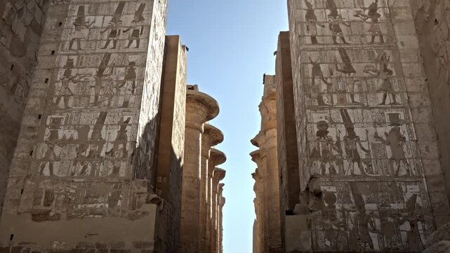 Located within the Karnak Temple Complex in Luxor, Egypt, this clip looks up at the massive stone architraves (horizontal beams) resting atop the columns of the Great Hypostyle Hall.