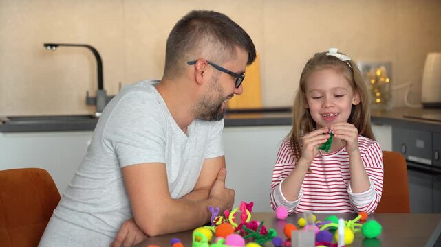 Happy family fun create diy from chenille wire. Father and little daughter make handmade craft. Leisure. Activities with children