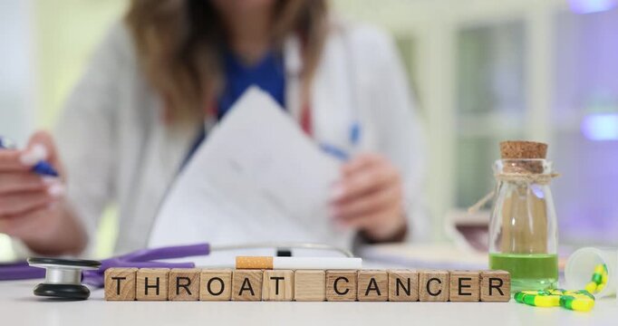 Wooden blocks spell words Throat Cancer near medicine bottle and scattered capsules. Doctor reviews report planning oncology referral for patient