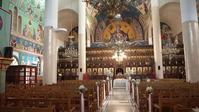 A tour inside an Orthodox church in Greece reveals beautiful murals on the walls and wooden icons. The bright colors and intricate designs capture attention.