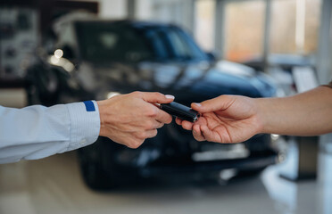 Ownership conception. Close up view of woman's and man's hands that are taking the keys for new car