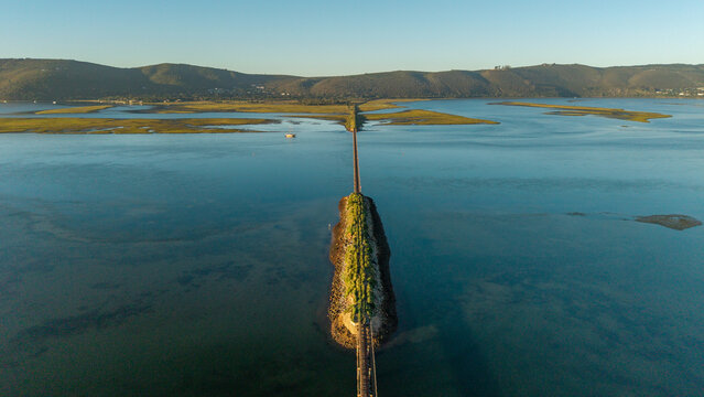 Aerial view of the bridge stretching across the water leading to the land with the mountains in the background, Knysna, Western Cape, South Africa.