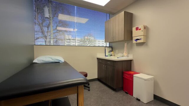 Empty doctor's office with exam table, lumbar spine model in a medical building waiting for someone to come in
