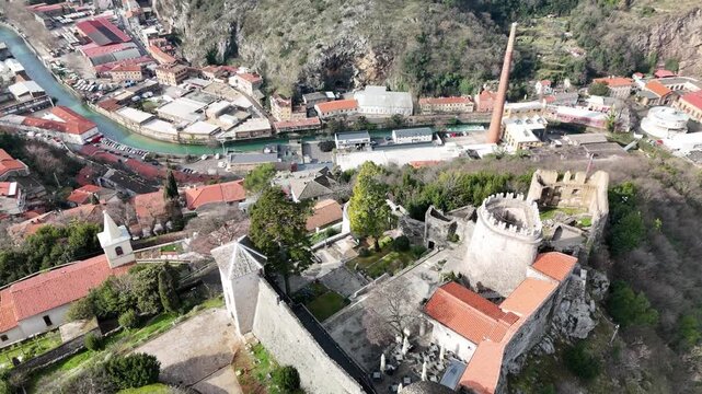 Drone hovers above Trsat Castle and lifts the camera to reveal the entire fortress, courtyard, Rijeka&rsquo;s skyline with skyscrapers, and the Adriatic coast in the distance.