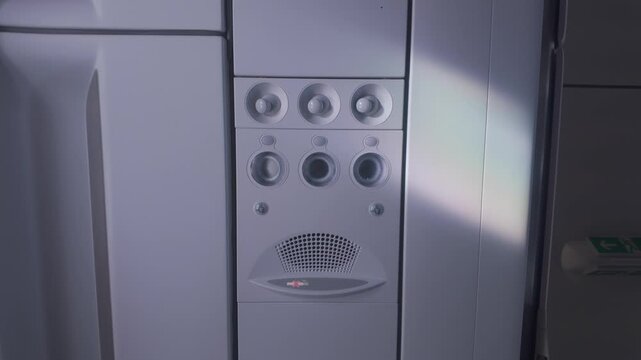 Plane overhead panel featuring personal air gaspers and reading lamp switches in the aircraft cabin ceiling, captured in a handheld camera shot