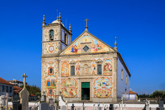 Colorful azulejo-covered church facade with biblical scenes under deep blue sky, Portugal, V&aacute;lega, 9 October 2025