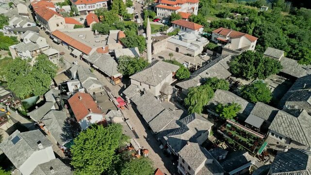 Bosnia and Herzegovina 05 28 2025: Angled dolly drone video from Hajji Kurts Mosque and Hamam Museum to Halebija Tower, Neretva River, Nezir Agina Dzamija, Old Bridge Mostar and Beach below Stari Most