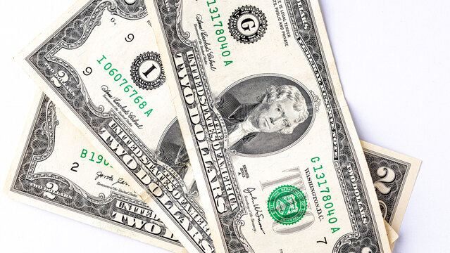 A detailed close-up image of multiple two-dollar bills featuring the portrait of Thomas Jefferson, arranged in an overlapping manner. Two american dollars banknote close up.