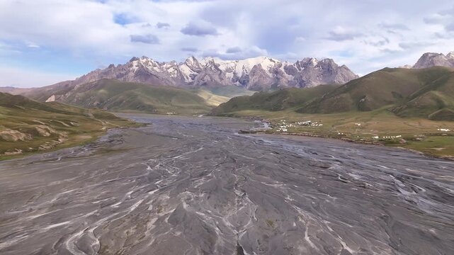 Aerial view of braided river plains in Kok-Kiya Valley with snow-capped Tian Shan mountains, Kyrgyzstan
