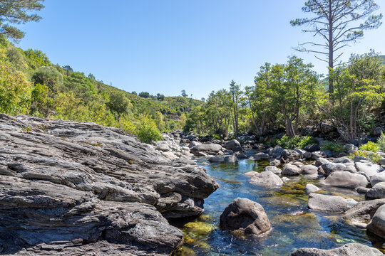 Clear river water flowing among rocks in Venaco, Corsica