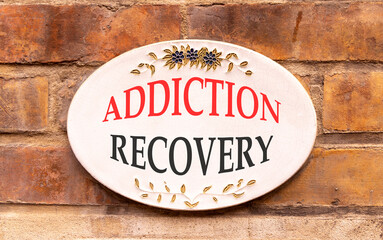 Addiction recovery symbol. Concept words Addiction recovery on beautiful big white sign plate. Beautiful old brown brick wall background. Psychology addiction recovery concept. Copy space.