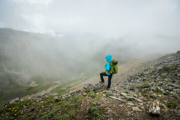 Obraz premium Woman hiking on high altitude mountain top