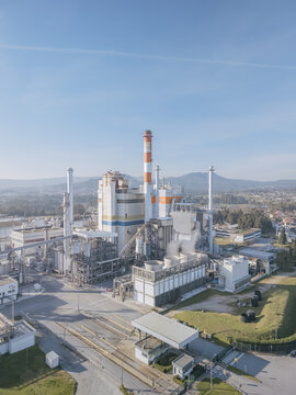 Aerial view of the DS Smith Paper mill industrial complex with towering structures and a striped chimney under a clear sky, Deocriste, Viana do Castelo, Portugal.