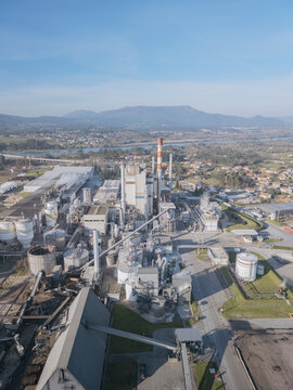 Aerial view of a sprawling DS Smith paper mill industrial complex with tall chimneys against a clear blue sky, Deocriste, Viana do Castelo, Portugal.
