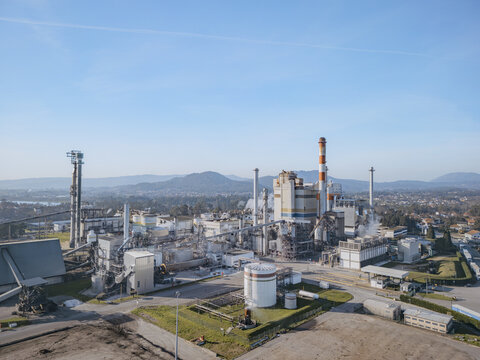 Aerial view of the DS Smith Paper mill industrial complex standing in stark contrast against the tranquil backdrop of distant mountains, Deocriste, Viana do Castelo, Portugal.