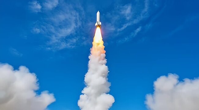 Dramatic image of a rocket launching with flames and smoke against blue sky