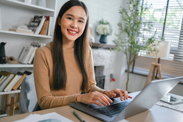 woman is sitting at a desk with a laptop in front of her
