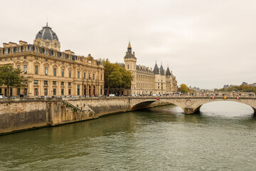 Obraz premium Seine River flowing past the Conciergerie, Palais de Justice, and Pont au Change bridge in Paris, France