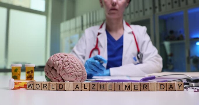 Wooden cubes on desk form phrase World Alzheimer Day. Psychiatrist writes detailed recommendations for patient diagnosed with disease of Alzheimer