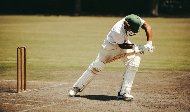 Cricket player batting on field during daytime game