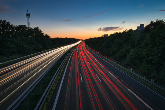 Long exposure of highway traffic at night on the A10 Berlin Ring near Dahlewitz, showing white and red car light trails and overhead road signs towards Dresden and Berlin-Tempelhof