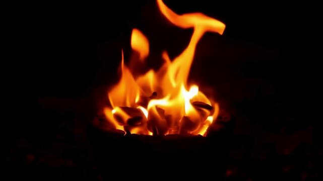 Warm Charcoal Fire Burning. Close-up of orange flames dancing over burning charcoal in a stove. Cozy traditional fire at night.